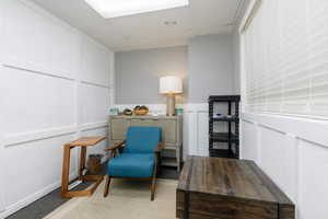 Living area with a decorative wall and a wainscoted wall