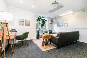 Office space featuring a decorative wall, wainscoting, and recessed lighting