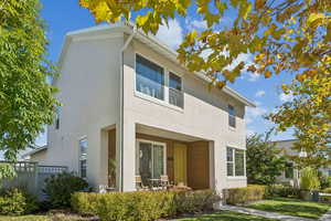 Rear view of house featuring stucco siding and a porch