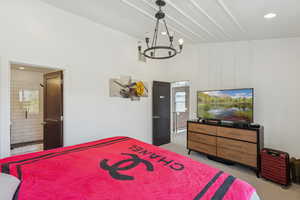 Bedroom with light colored carpet, connected bathroom, recessed lighting, and a chandelier
