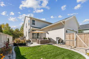 Back of house with a fenced backyard, a gate, an outdoor hangout area, a patio area, and stucco siding
