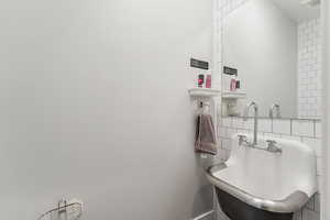 Bathroom with decorative backsplash and tile walls
