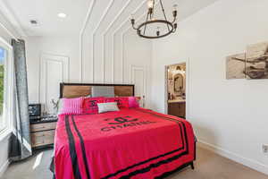 Carpeted bedroom with a chandelier, ensuite bathroom, recessed lighting, and vaulted ceiling