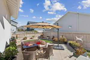 Fenced backyard featuring an outdoor living space with a fire pit and a patio