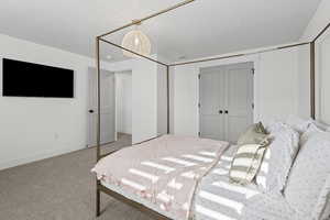 Carpeted bedroom with baseboards and a closet