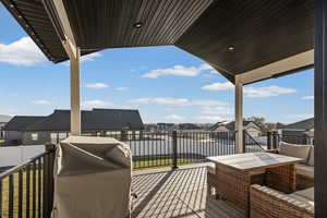 Deck featuring a patio, a residential view, and a grill
