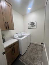 Laundry room featuring cabinet space and separate washer and dryer