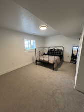 Bedroom with a textured ceiling and carpet