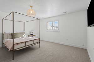 Bedroom featuring light carpet and a textured ceiling