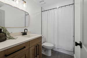 Full bathroom with vanity, shower / bath combo, and dark tile patterned flooring