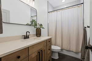 Bathroom featuring vanity, dark tile patterned floors, and shower / bath combo