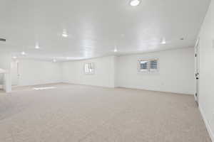Spare room featuring light carpet, recessed lighting, and a textured ceiling