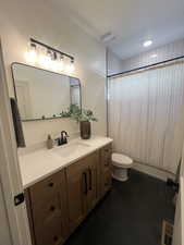 Bathroom featuring shower / tub combo with curtain, vanity, recessed lighting, and dark tile patterned floors