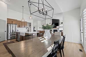 Dining area featuring light wood finished floors, a chandelier, recessed lighting, and high vaulted ceiling