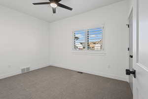 Carpeted empty room with baseboards and ceiling fan