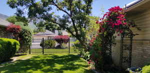 Stunning garden with a rose covered arbor and an array of colorful flowers and trees.