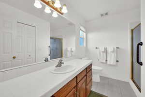 Primary bathroom with large cabinet and spacious tiled shower