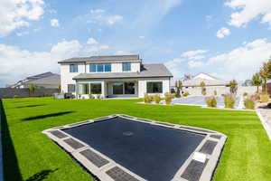 Rear view of property with a patio, stucco siding, and basketball hoop