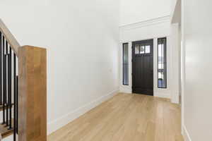 Foyer entrance with light wood-style floors and a high ceiling