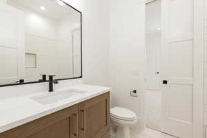 Bathroom with vanity, light tile patterned floors, and recessed lighting