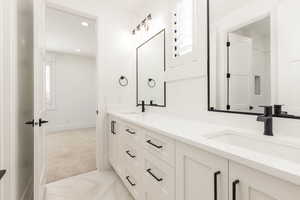 Full bathroom with double vanity, recessed lighting, and light carpet