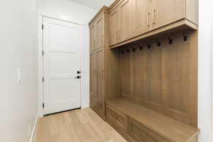 Mudroom with light wood-type flooring and baseboards