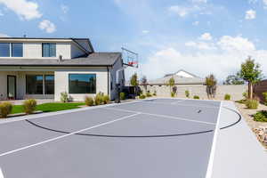 View of basketball court featuring basketball hoop and a fenced backyard