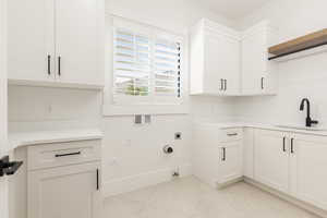 Laundry area with hookup for a gas dryer, washer hookup, electric dryer hookup, cabinet space, and light tile patterned flooring