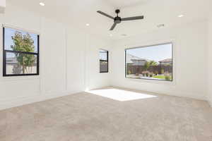 Unfurnished room featuring light colored carpet, a decorative wall, recessed lighting, and ceiling fan