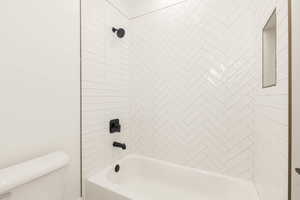 Bathroom featuring tub / shower combination and toilet