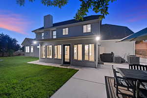 Back of house featuring a patio, a chimney, and stucco siding
