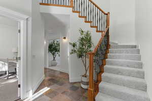 Staircase featuring baseboards and stone finish flooring