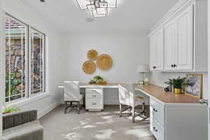 Office area featuring light carpet and baseboards