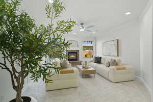 Carpeted living area featuring ornamental molding, a fireplace, ceiling fan, and recessed lighting