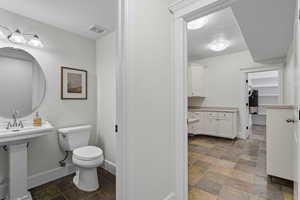 Half bath with stone finish flooring and baseboards