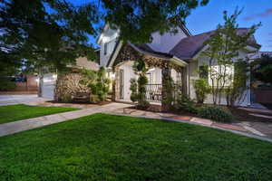 View of front facade featuring stone siding, driveway, a garage, and stucco siding