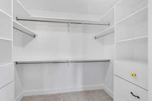 Spacious closet with light colored carpet