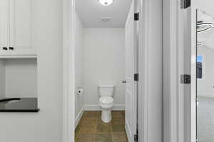 Bathroom with toilet and baseboards