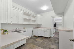 Laundry area featuring washer hookup, cabinet space, and stone finish flooring