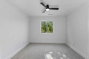 Spare room featuring light colored carpet and ceiling fan
