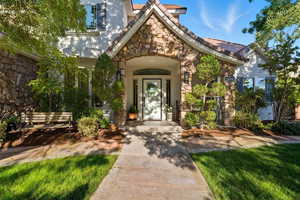 Entrance to property with stone siding and stucco siding