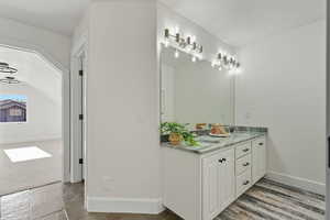 Bathroom featuring double vanity, light colored carpet, and a textured ceiling