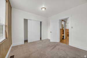 Unfurnished bedroom featuring a closet and light colored carpet