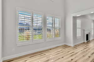 Unfurnished living room featuring a fireplace and light wood-type flooring