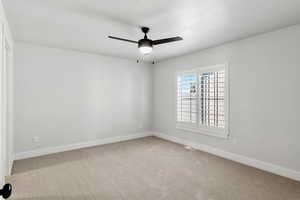 Spare room with light carpet and ceiling fan