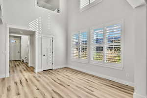 Entrance foyer with a towering ceiling and light wood-style flooring