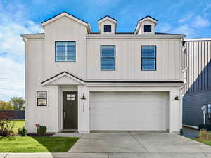 Modern farmhouse style home with an attached garage, board and batten siding, and concrete driveway