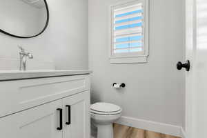 Half bath with vanity and light wood finished floors