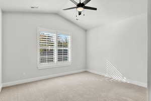 Spare room with light carpet, lofted ceiling, and ceiling fan