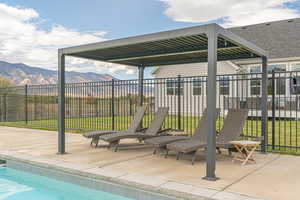 Heated saltwater pool with Baja shelf, cyclone slide, concrete pool deck, and wrought-iron fence for added safety.
